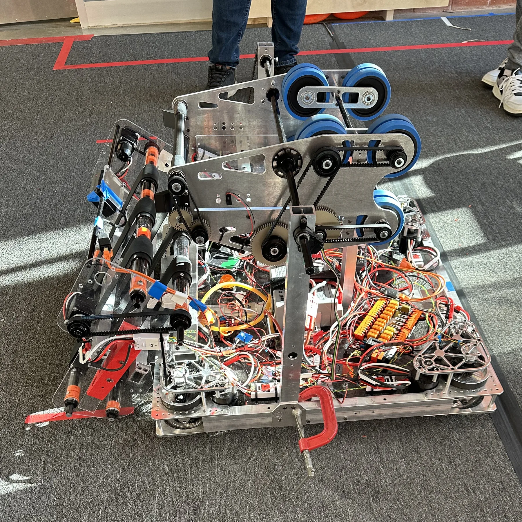 Top-down view of the 2024 swerve drive base mid-build, with the electronics, wiring and blue shooter wheels exposed