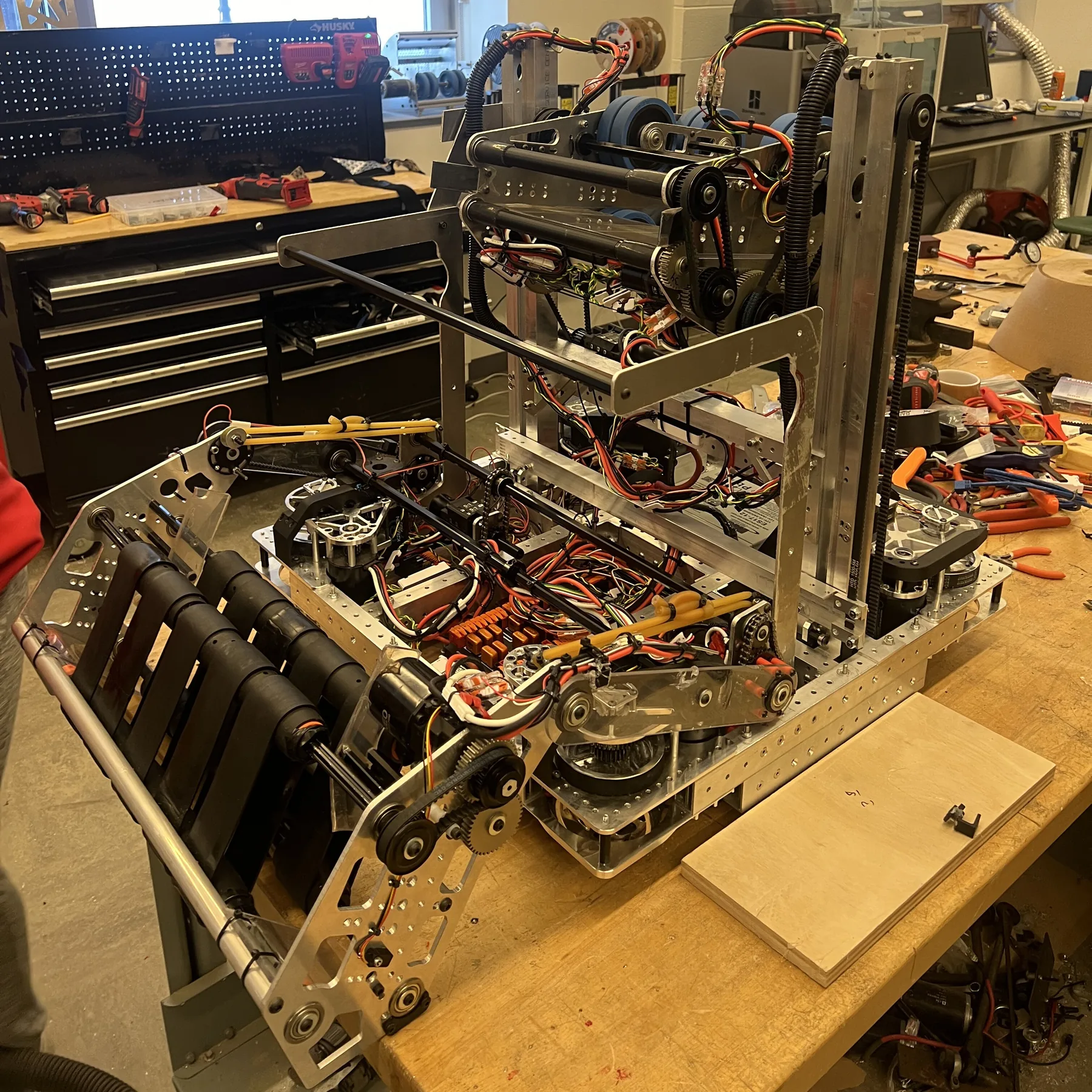 The 2024 robot on a workbench with the two-stage elevator and shooter assembled on the drive base