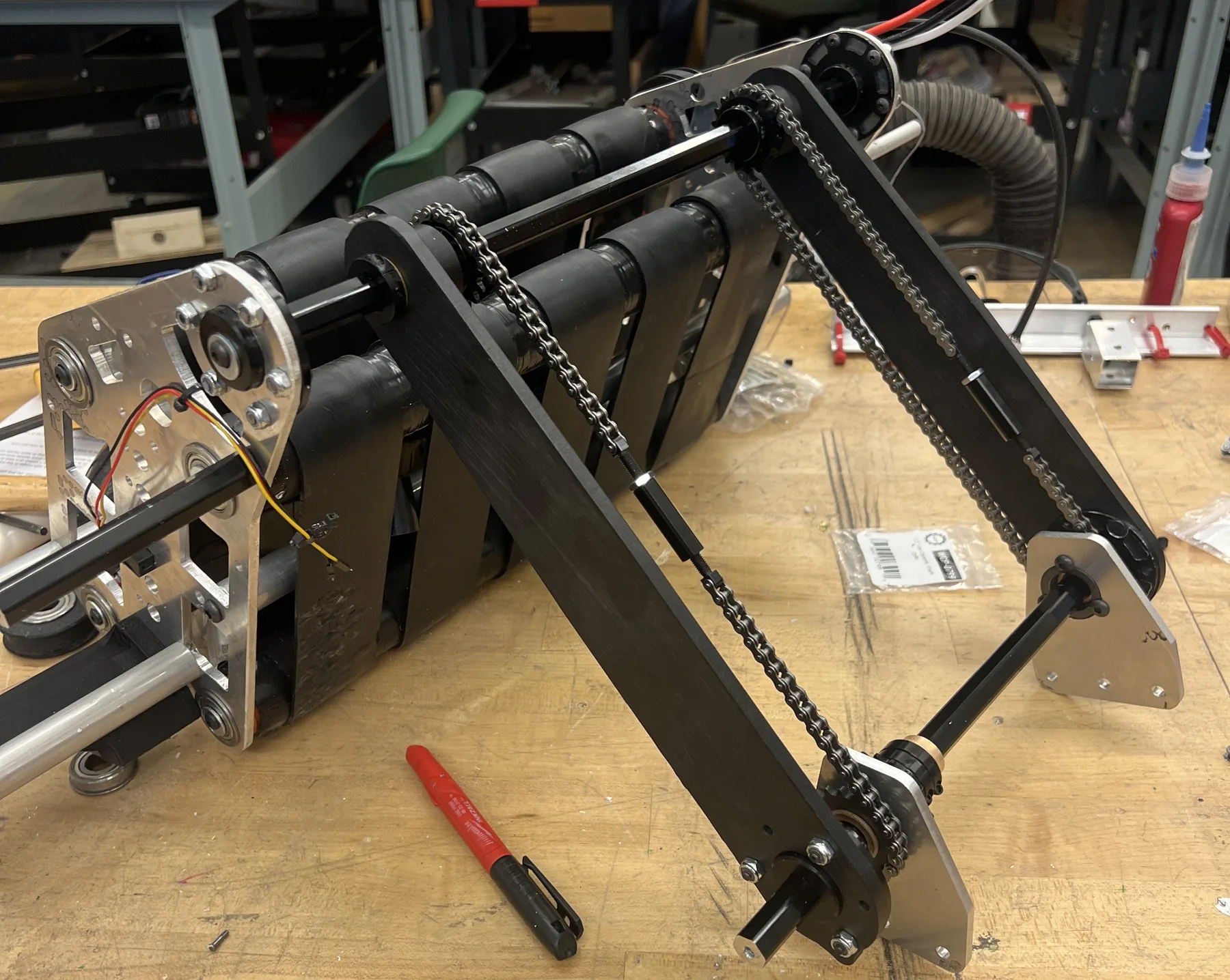 Final intake V7 with black nylon arms, chain drive and sensor wiring on the workbench