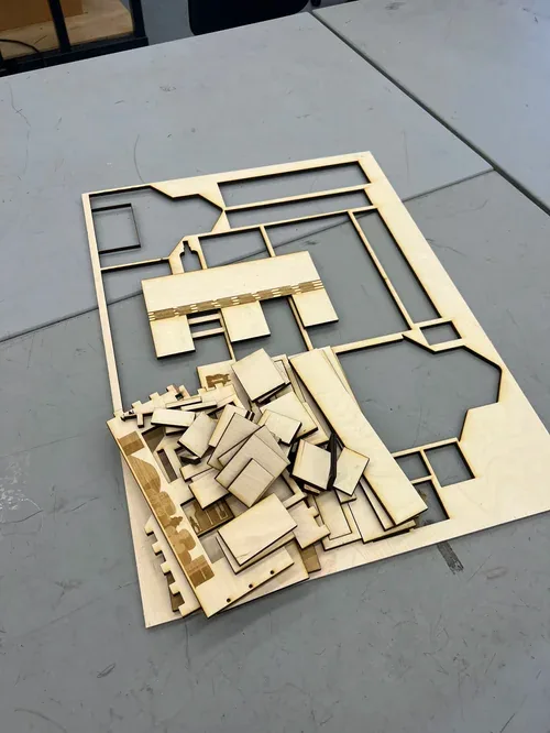 Freshly cut plywood sheet with the barn parts still in the frame, pieces piled on top