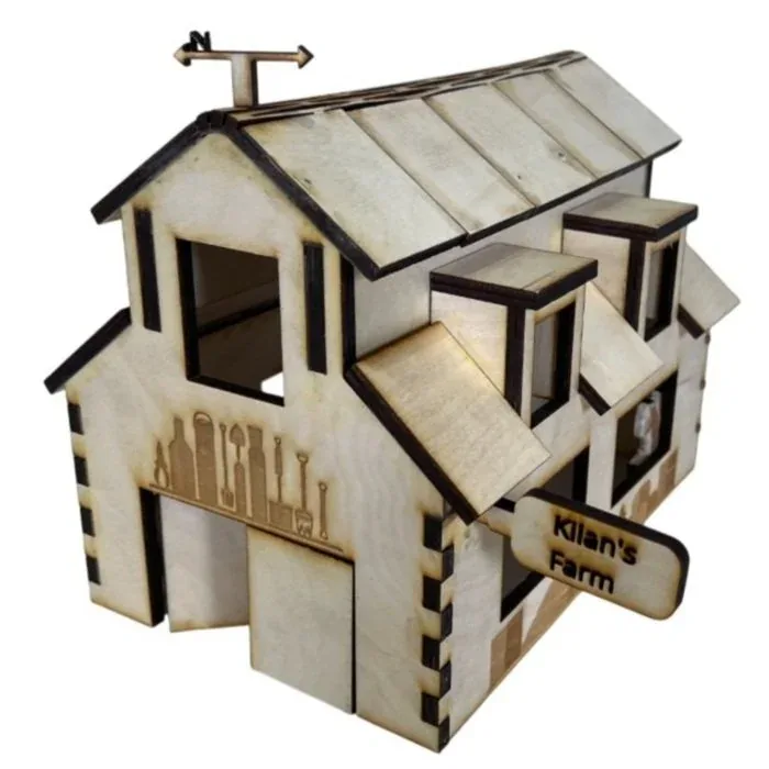 Finished laser-cut plywood barn with a weather vane, dormer windows, engraved farm tools on the walls and a 'Kilan's Farm' sign over the door
