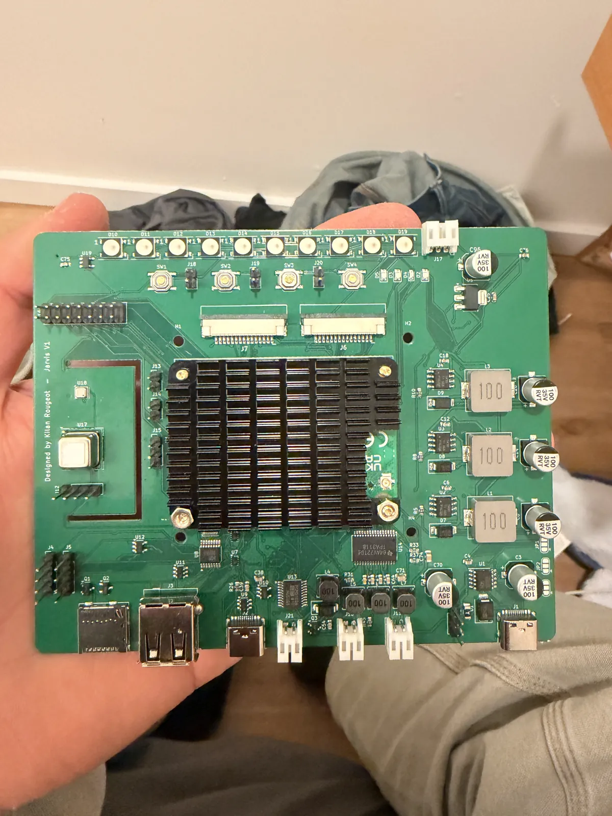 The rev A board held in hand with the Compute Module 4 and its black heatsink fitted