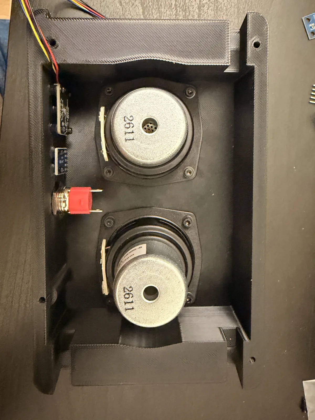 The two small speakers mounted inside the back cover with their leads to the JST connectors