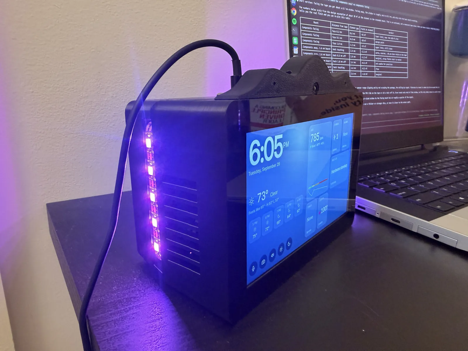 The finished HomeDeck on a desk at night, screen on, with the LED bar lit purple down its side