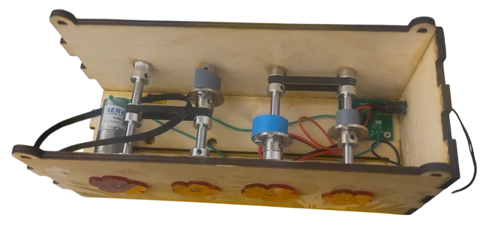Underside view of the box showing the motor, belts, pulleys and wiring mounted to the base panel